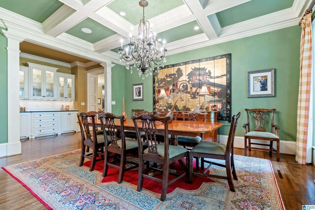 dining area with coffered ceiling, dark hardwood / wood-style floors, ornate columns, and a chandelier