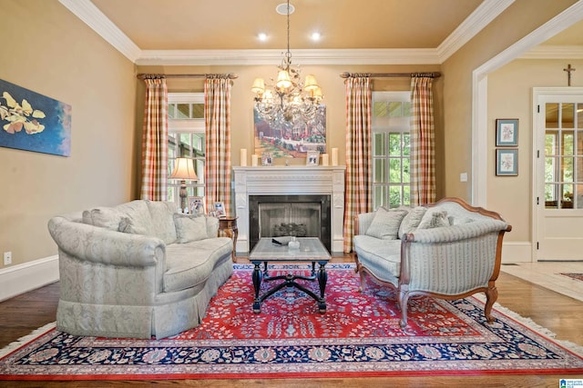 living room with a notable chandelier, hardwood / wood-style flooring, and ornamental molding