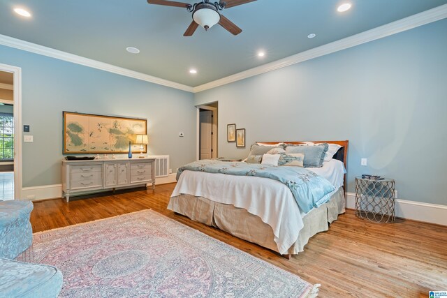 bedroom featuring light hardwood / wood-style floors, ceiling fan, and crown molding