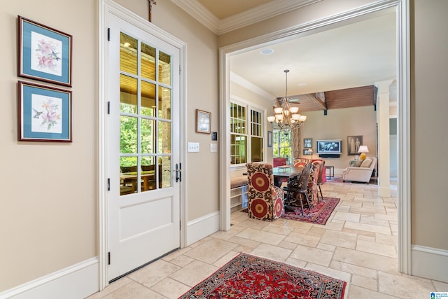 entrance foyer with ornamental molding and a chandelier