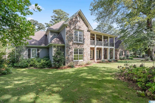 rear view of property with a balcony and a yard