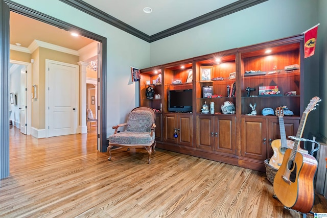 living area with light wood-type flooring and crown molding