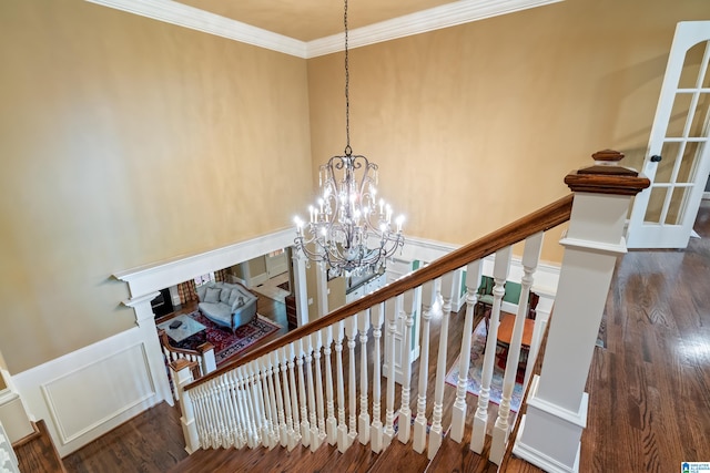 stairway featuring a notable chandelier, hardwood / wood-style flooring, and crown molding