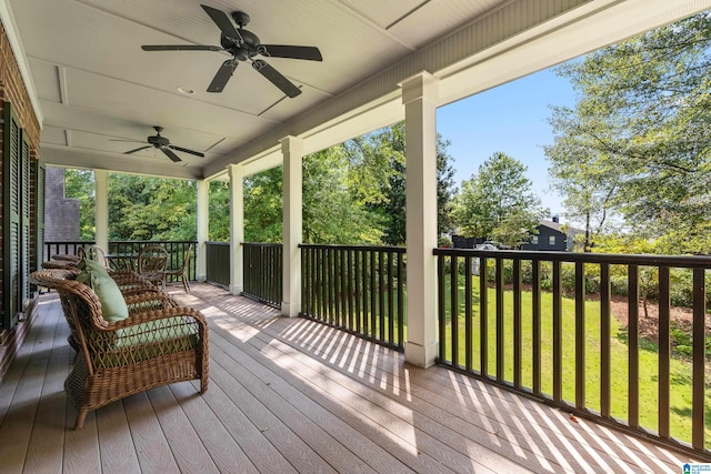 wooden terrace featuring a lawn and ceiling fan