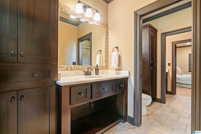 bathroom featuring ornamental molding, vanity, and toilet