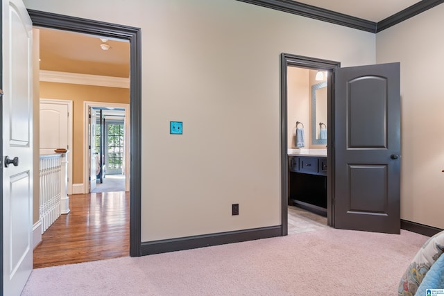 unfurnished bedroom featuring connected bathroom, crown molding, and light hardwood / wood-style floors