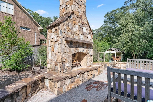 view of patio featuring an outdoor stone fireplace