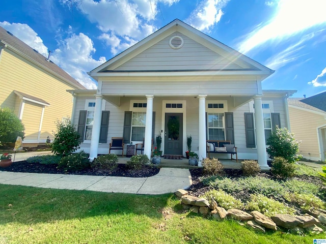 neoclassical home featuring covered porch and a front yard