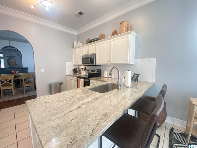 kitchen with decorative backsplash, appliances with stainless steel finishes, light tile patterned floors, and sink