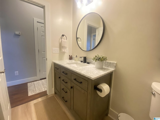 bathroom featuring toilet, vanity, and hardwood / wood-style flooring