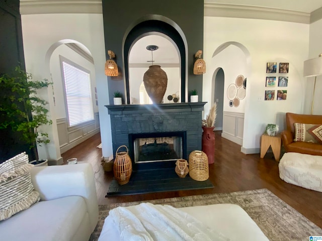 living area with a multi sided fireplace, dark hardwood / wood-style floors, and crown molding