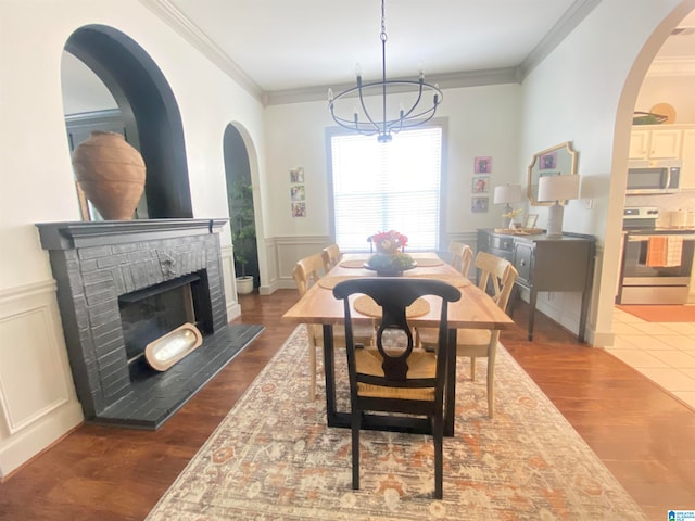 dining area featuring crown molding, a fireplace, and dark wood-type flooring