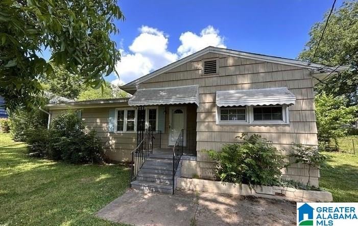 bungalow-style home with a front yard