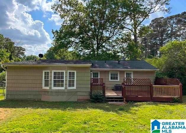 back of house featuring a deck and a yard