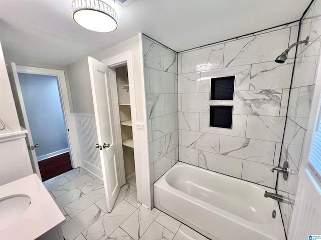 bathroom featuring tiled shower / bath combo and vanity