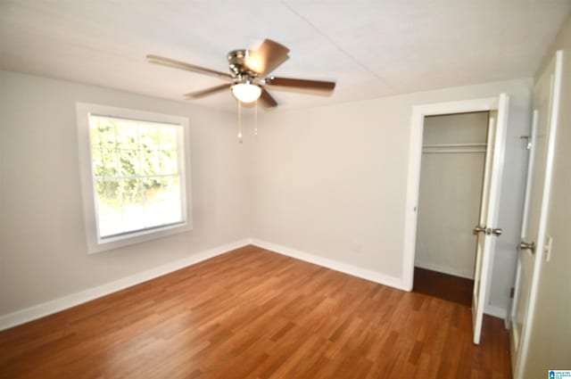 unfurnished bedroom featuring wood-type flooring, a closet, and ceiling fan