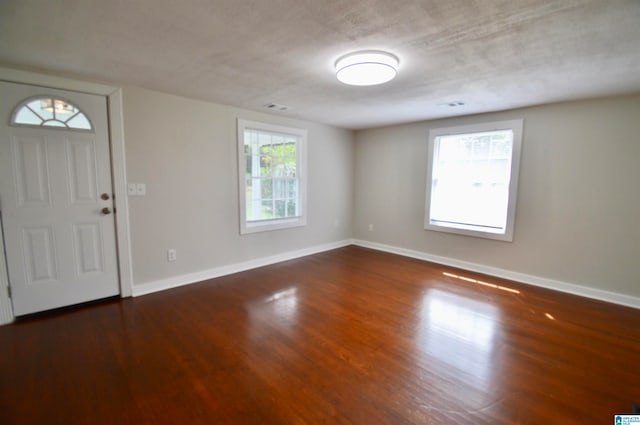 entrance foyer featuring a textured ceiling and dark wood-type flooring