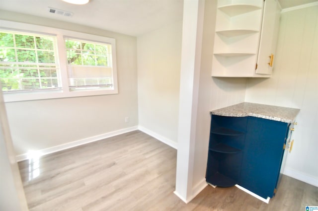 interior space featuring white cabinetry, light wood-type flooring, and blue cabinets