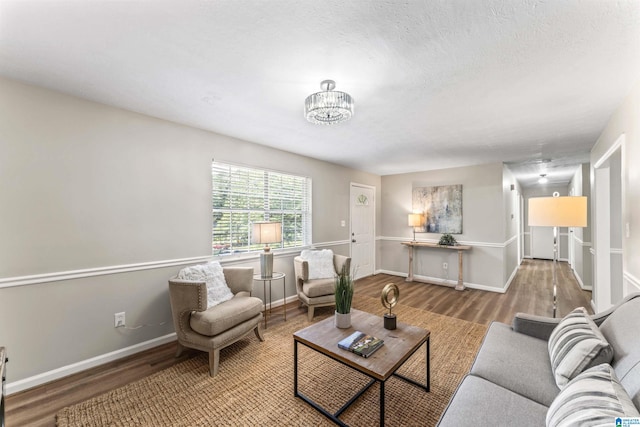 living room with a textured ceiling, light hardwood / wood-style flooring, and a notable chandelier