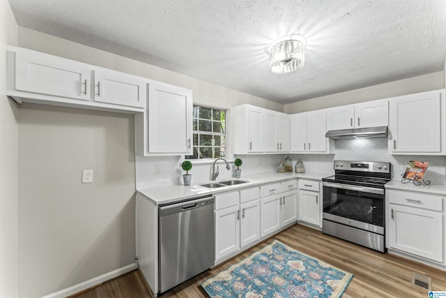 kitchen with light hardwood / wood-style floors, sink, white cabinetry, backsplash, and appliances with stainless steel finishes