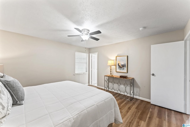 bedroom featuring a textured ceiling, ceiling fan, and dark hardwood / wood-style flooring