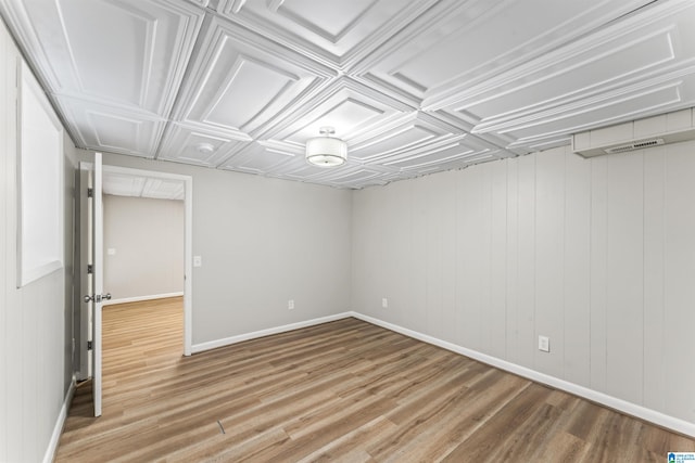 basement with wood walls and hardwood / wood-style flooring