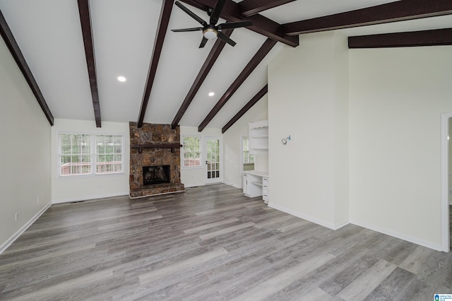 unfurnished living room with lofted ceiling with beams, light hardwood / wood-style flooring, and a wealth of natural light