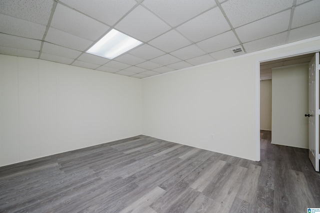 unfurnished room with wood-type flooring and a drop ceiling