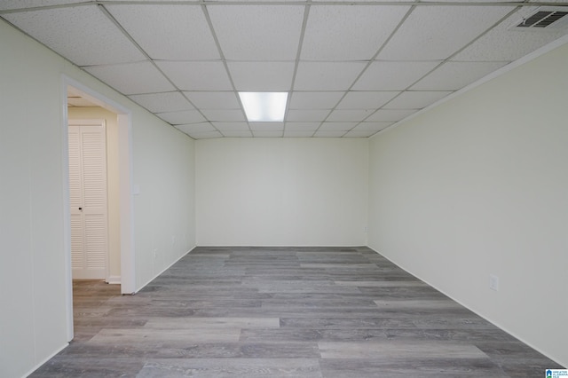 unfurnished room with wood-type flooring and a paneled ceiling