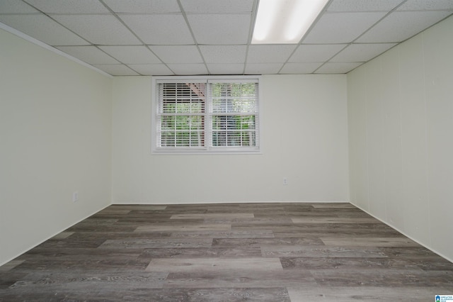 empty room featuring a paneled ceiling and wood-type flooring