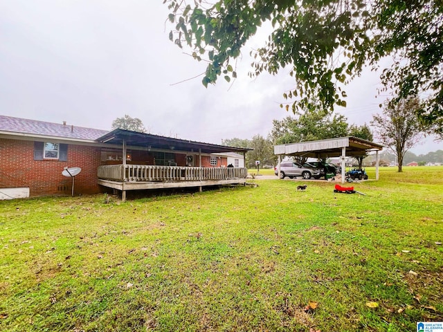 view of yard with a wooden deck and a carport