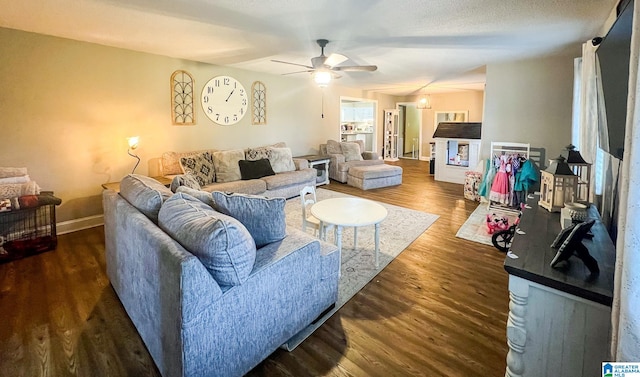 living room with ceiling fan and dark wood-type flooring