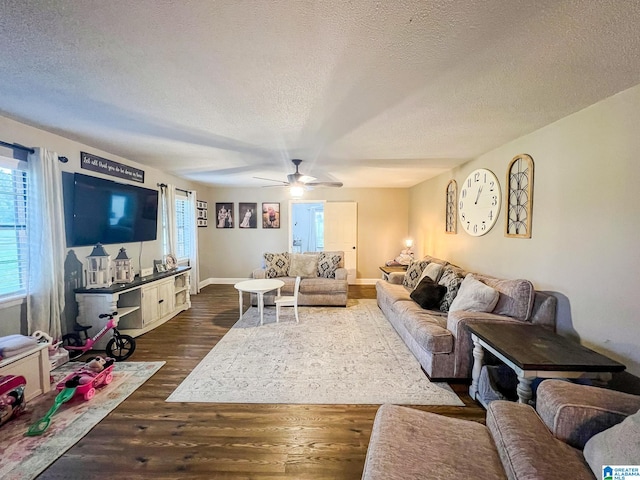 living room featuring ceiling fan, dark hardwood / wood-style floors, and a textured ceiling