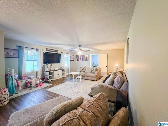 living room featuring a textured ceiling, dark hardwood / wood-style floors, and ceiling fan