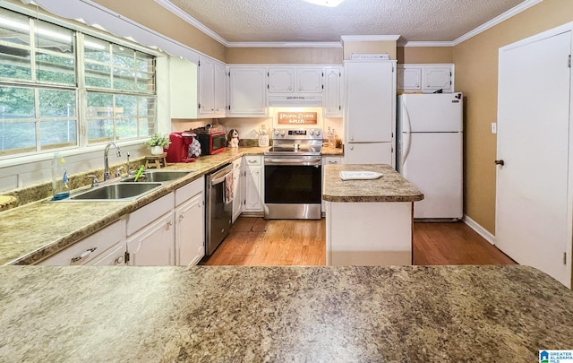 kitchen with a textured ceiling, light hardwood / wood-style floors, stainless steel appliances, and white cabinets