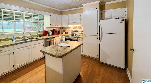 kitchen featuring white cabinetry, stainless steel appliances, light wood-type flooring, a center island, and sink