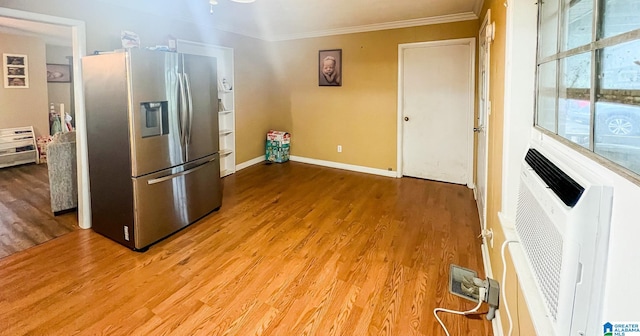 kitchen with wood-type flooring, stainless steel fridge, and ornamental molding