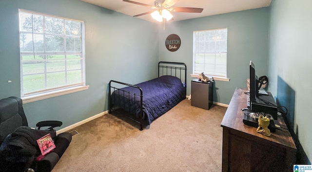 carpeted bedroom with multiple windows and ceiling fan