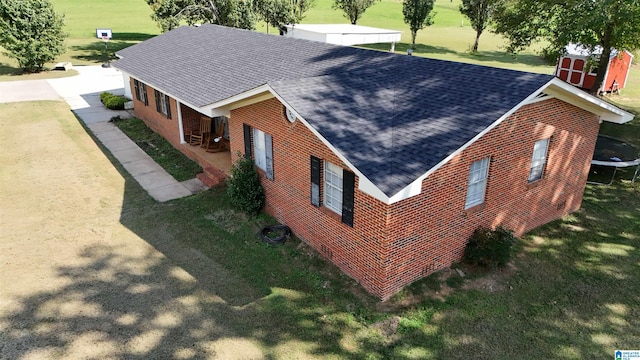 view of home's exterior with a lawn and a trampoline