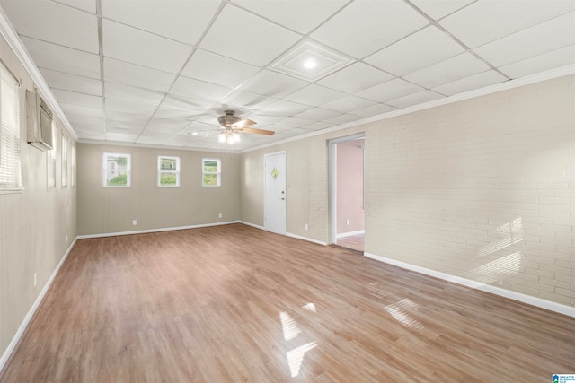 spare room featuring ceiling fan, a paneled ceiling, ornamental molding, and wood-type flooring