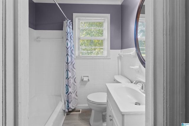 full bathroom featuring tile walls, shower / bath combo, vanity, and toilet