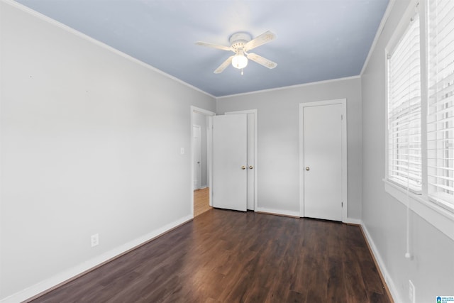 unfurnished bedroom with ceiling fan, ornamental molding, and dark hardwood / wood-style flooring