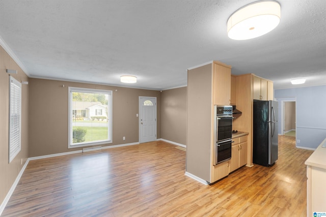 kitchen with stainless steel refrigerator, light hardwood / wood-style flooring, ornamental molding, and a textured ceiling