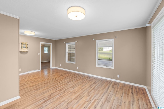 empty room with crown molding and light hardwood / wood-style flooring