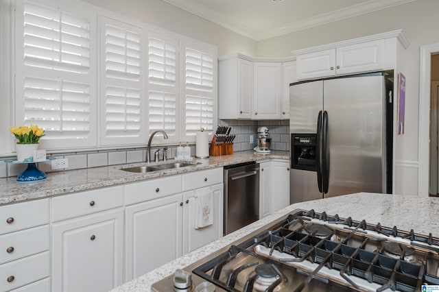 kitchen featuring sink, white cabinets, backsplash, appliances with stainless steel finishes, and ornamental molding