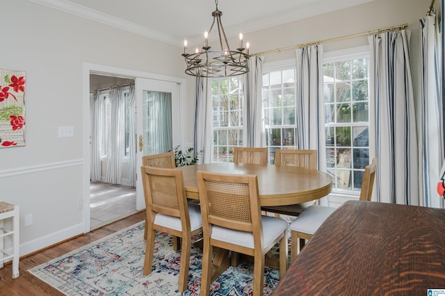 dining space with ornamental molding, an inviting chandelier, and hardwood / wood-style floors