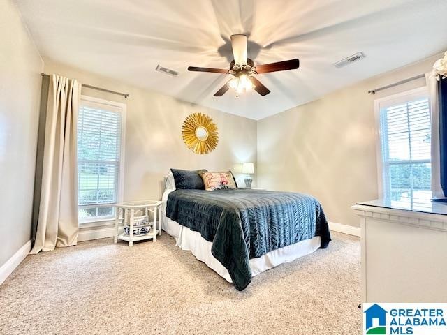 bedroom featuring ceiling fan, carpet floors, and multiple windows