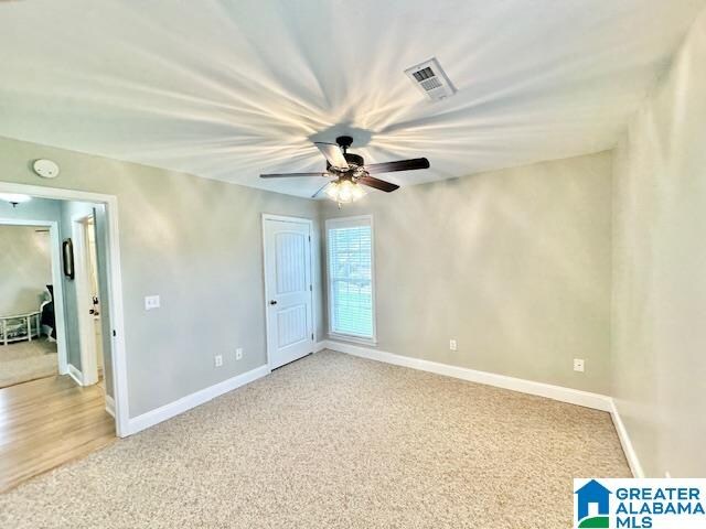 unfurnished room with carpet and ceiling fan