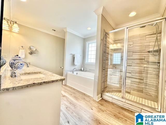 bathroom with wood-type flooring, vanity, plus walk in shower, and ornamental molding