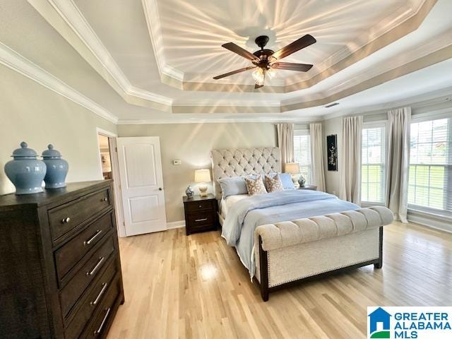 bedroom with ceiling fan, light hardwood / wood-style floors, a raised ceiling, and ornamental molding